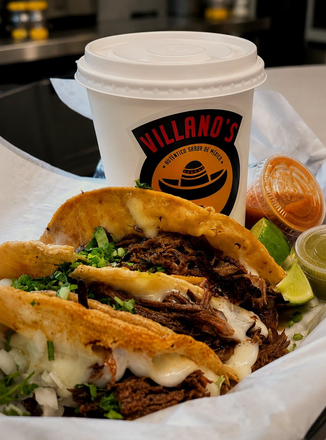 Tacos de birria con queso y consomé en vaso de Villano's Tacos